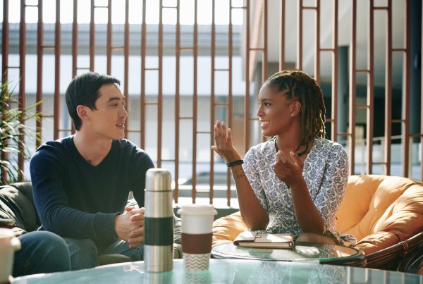 A man and woman having an informal work meeting over coffee